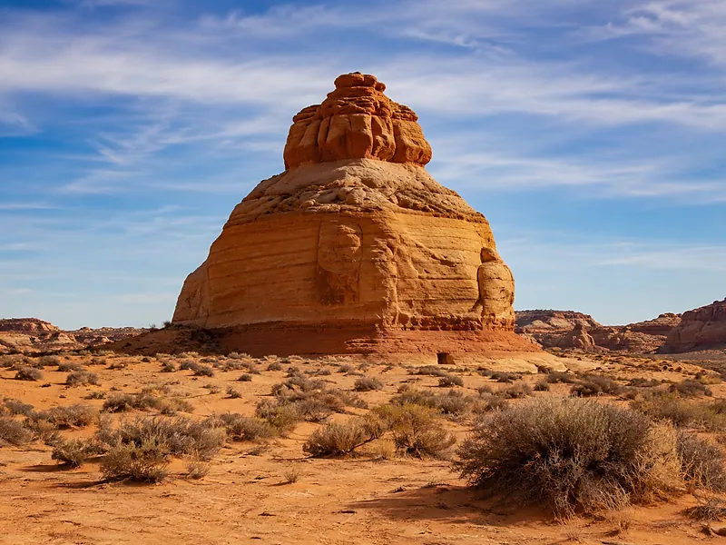 Red rock butte above desert scrub under a clear sky
