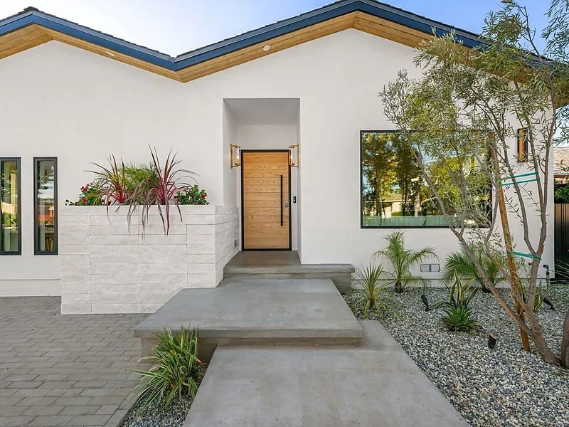 White stucco home with a gravel xeriscape entry walk