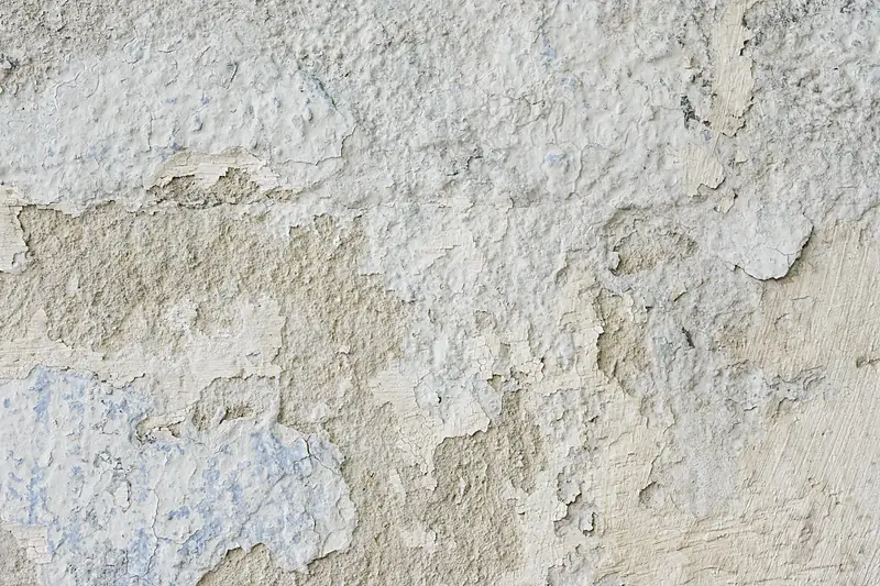 Coating flaking away from a plaster wall in loose patches